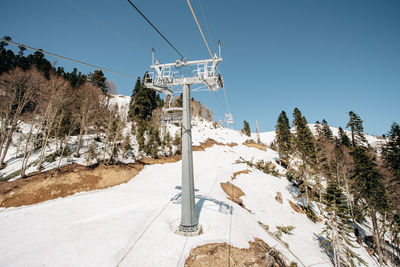Ski lift by snowcapped mountain against sky