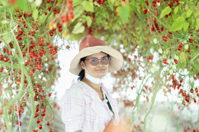 Portrait of man wearing hat standing against plants