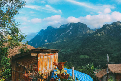 View of cottage on mountain against sky