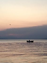 Silhouette boat on sea against sky during sunset