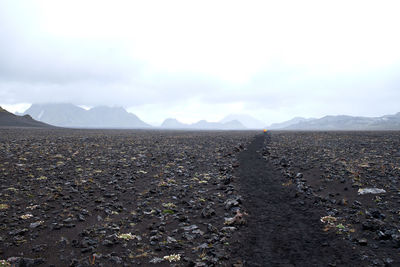 Scenic view of land and mountains against sky