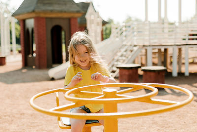 A charming little girl is walking in the park, swinging on a swing. happy childhood, playtime