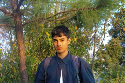 Portrait of young man standing in forest