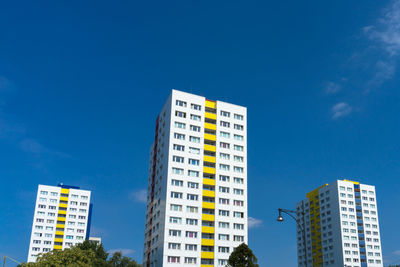 Low angle view of modern buildings against blue sky