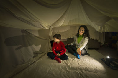 Full length of mother sitting at tent