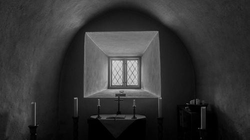 Empty chairs and table against wall in building