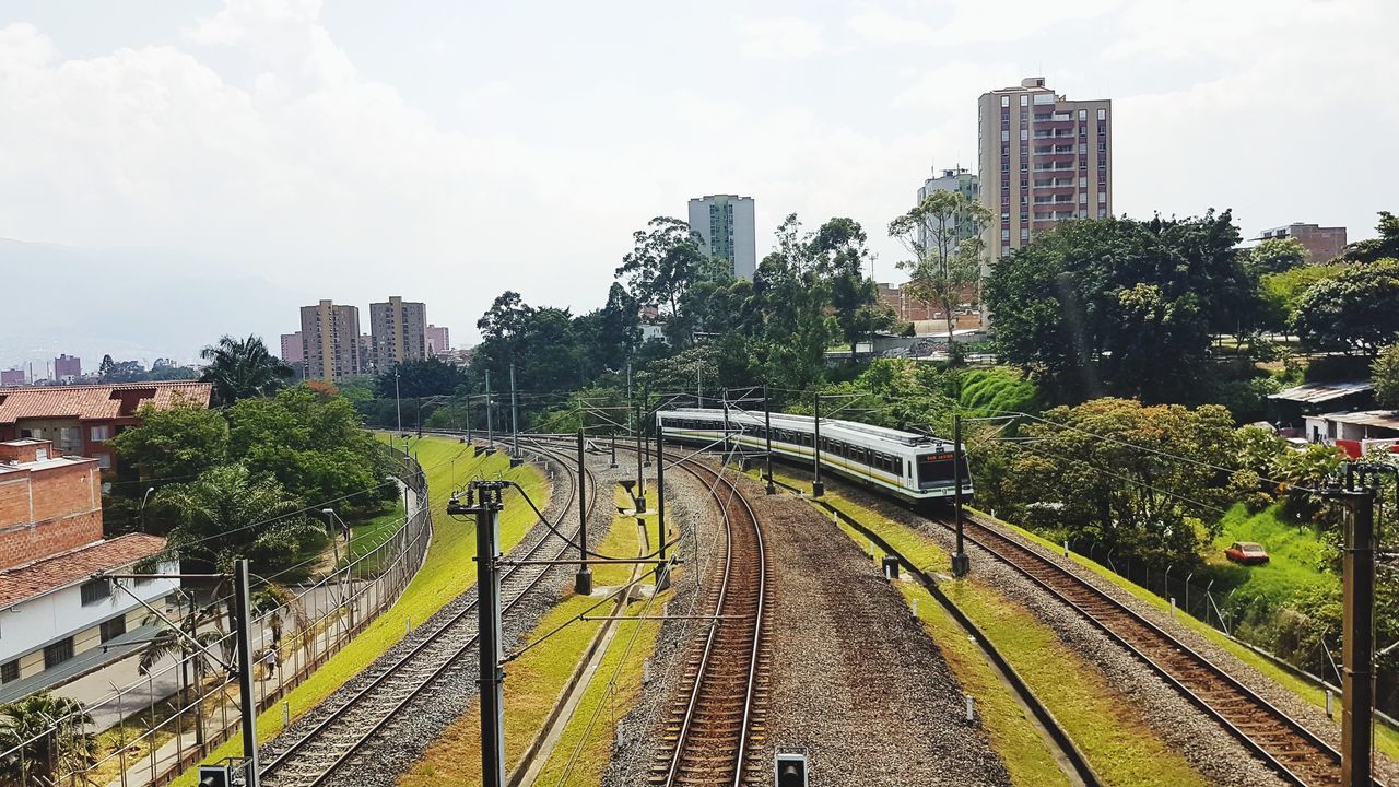 PANORAMIC VIEW OF RAILROAD TRACKS AMIDST BUILDINGS IN CITY