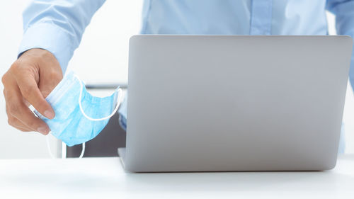 Midsection of man using laptop on table