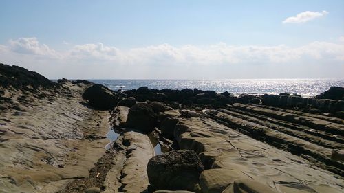 Rocks on beach against sky