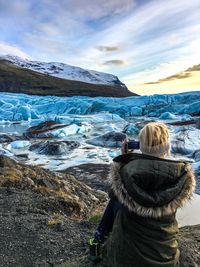 Rear view of woman photographing nature