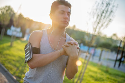 Young man looking away while standing outdoors