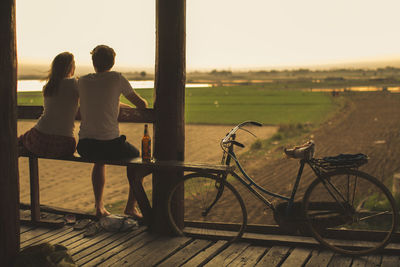 Rear view of people on bicycle against sky