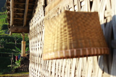 Close-up of wicker basket hanging on wooden fence