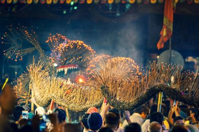 People with burning incense in city at night