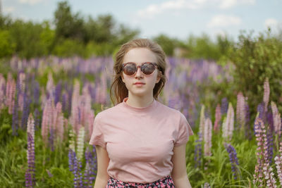Beautiful young woman in the field of lupins