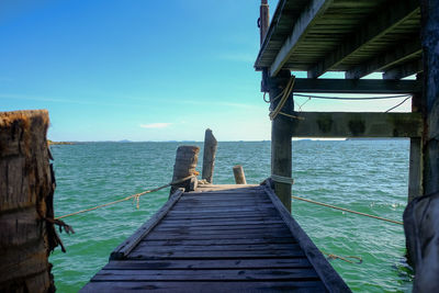 Pier over sea against blue sky