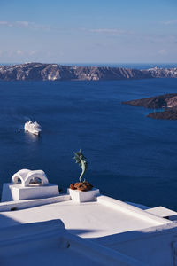 Seahorse statue in a beautiful white terrace in santorini island, greece - caldera view