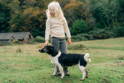 Little girl walking in the village with her dog.