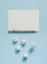 Yahtzee game in progress. rolling dice, pencil and score sheet on a blue background.