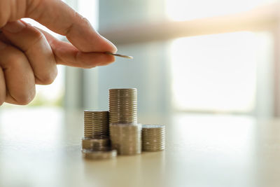 Close-up of hand holding coin stack