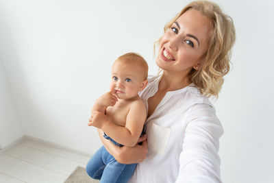 Portrait of mother with daughter against white background