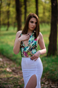 Beautiful young woman standing in a forest