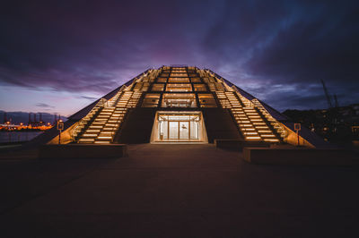 Illuminated building against sky at dusk