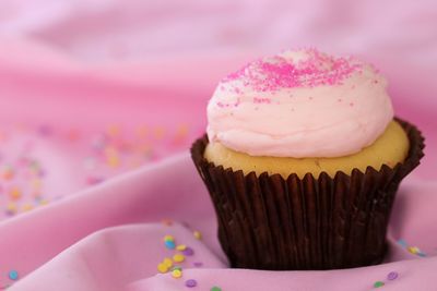 Close-up of cupcakes on pink cake