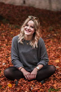 Portrait of a smiling young woman with autumn leaves