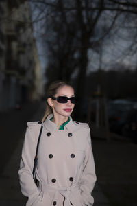 Portrait of young woman wearing sunglasses while standing outdoors