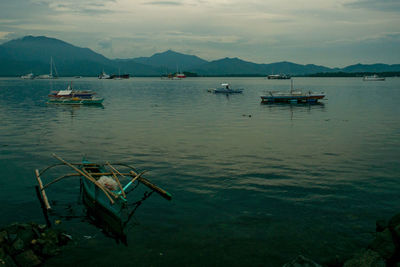 Boats moored in lake against sky