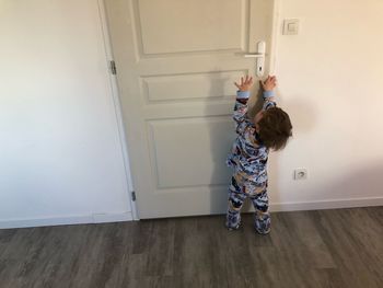 Boy trying to open door of home