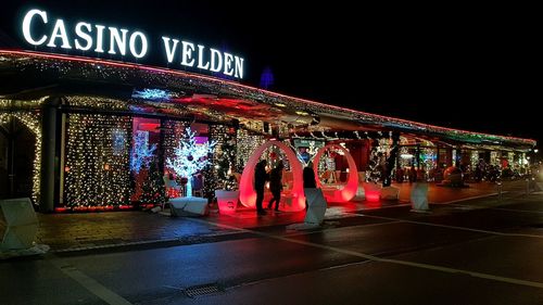 Group of people walking in illuminated building at night