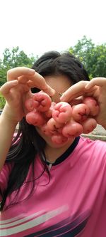 Close-up of woman holding pink flowers