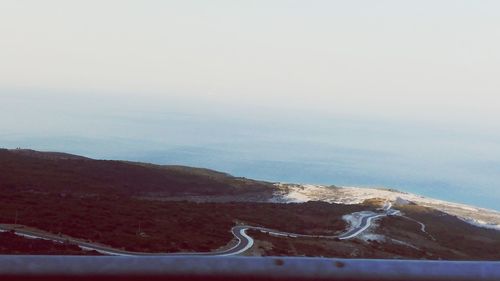 Scenic view of road by sea against sky