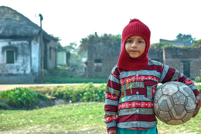 Portrait of boy wearing hat standing in field