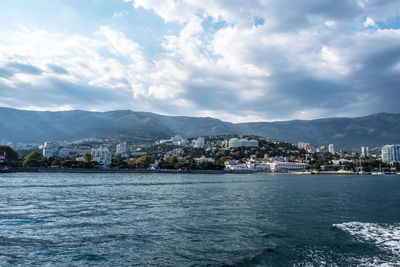 Scenic view of sea by buildings against sky