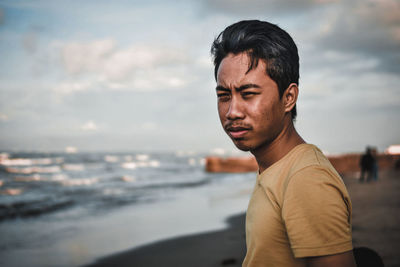 Portrait of man looking at sea against sky