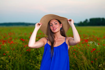 Portrait of young woman standing on field