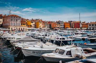 Boats moored in harbor against buildings in city