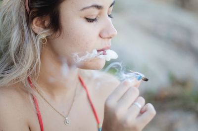 Close-up of woman smoking marijuana joint