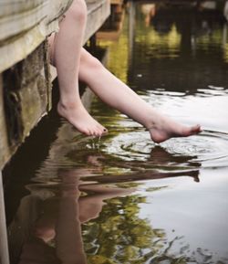 Low section of woman with reflection in lake