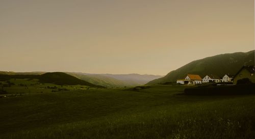 Scenic view of field and mountains against sky