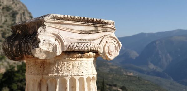 Close-up of cross on mountain against sky