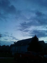 Silhouette of trees and houses against sky