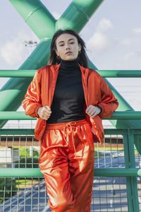 Confident young woman standing on bridge