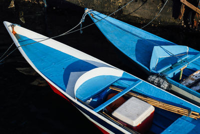 High angle view of blue boats moored by ropes in canal