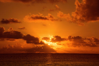 Scenic view of sea against dramatic sky during sunset