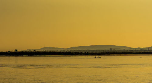 Scenic view of sea against orange sky