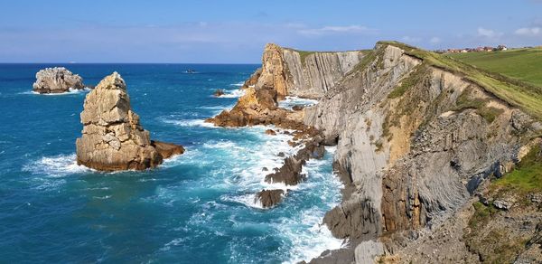 Panoramic view of rocks on beach against sky